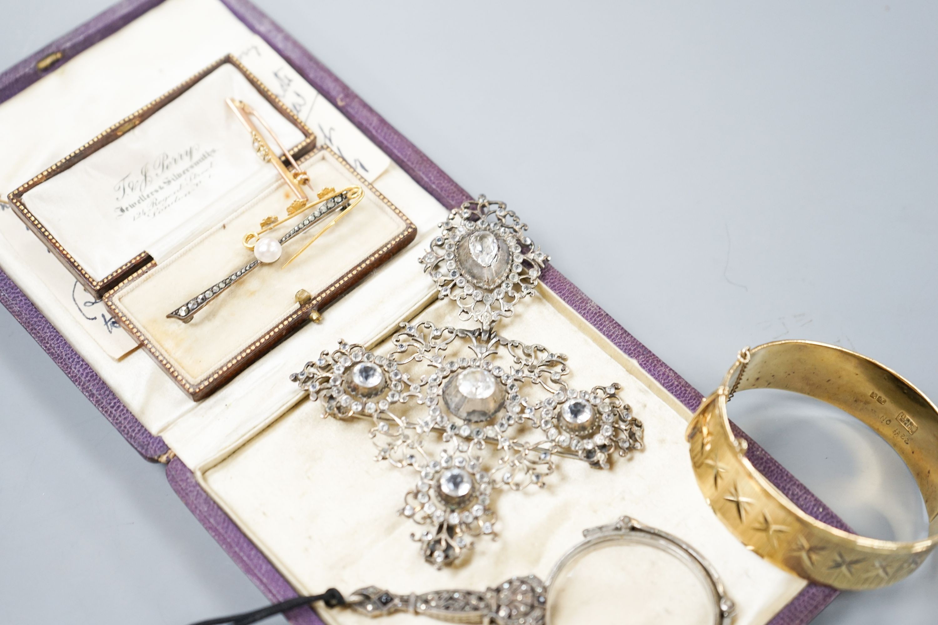 A white metal and paste set drop pendant, 10.7cm, a modern silver gilt bangle, a 9ct gold bar brooch, two other brooches and a marcasite set lorgnettes.